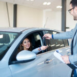 vehicle-dealer-handing-keys-new-car-owner
